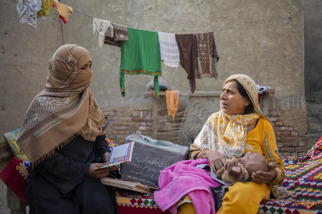 Sukkur, Pakistan, lady health supervisor Alma Khatoon speaks with Mumtaz Azizullah at her home and checks the vaccine card for her 1-month-old daughter to make sure her vaccinations are up to date. Credit: Saiyna Bashir ǀ Chemonics International.