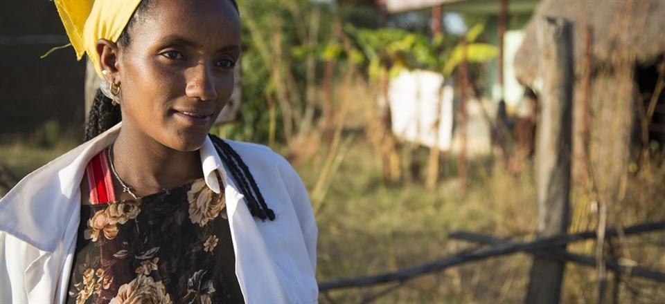 Yetagesu Alema, a frontline health worker, is standing in front of the Germana Gale Health Post in Ethiopia. Photo courtesy: Save the Children