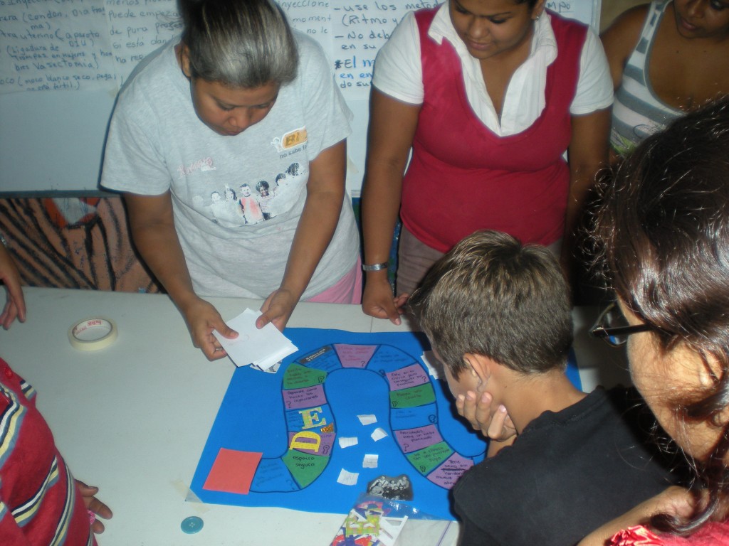 A group in Nicaragua field tests an educational board game. Courtesy Hesperian Health Guides.